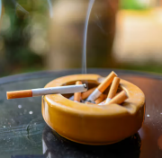 Cigarette burning with smoking on ashtray